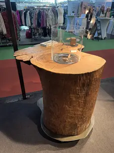Design-Stehtisch aus Eschen-Baumstamm mit Naturkante und zentralem Feuerbereich
