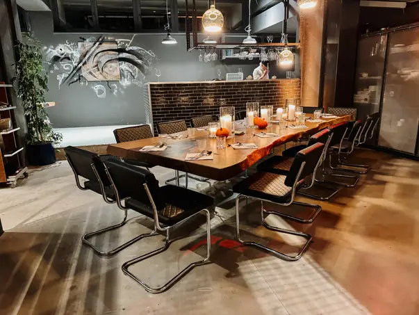 Mesa de comedor elegante de castaño con borde natural y tapa de vidrio transparente para hasta 14 invitados