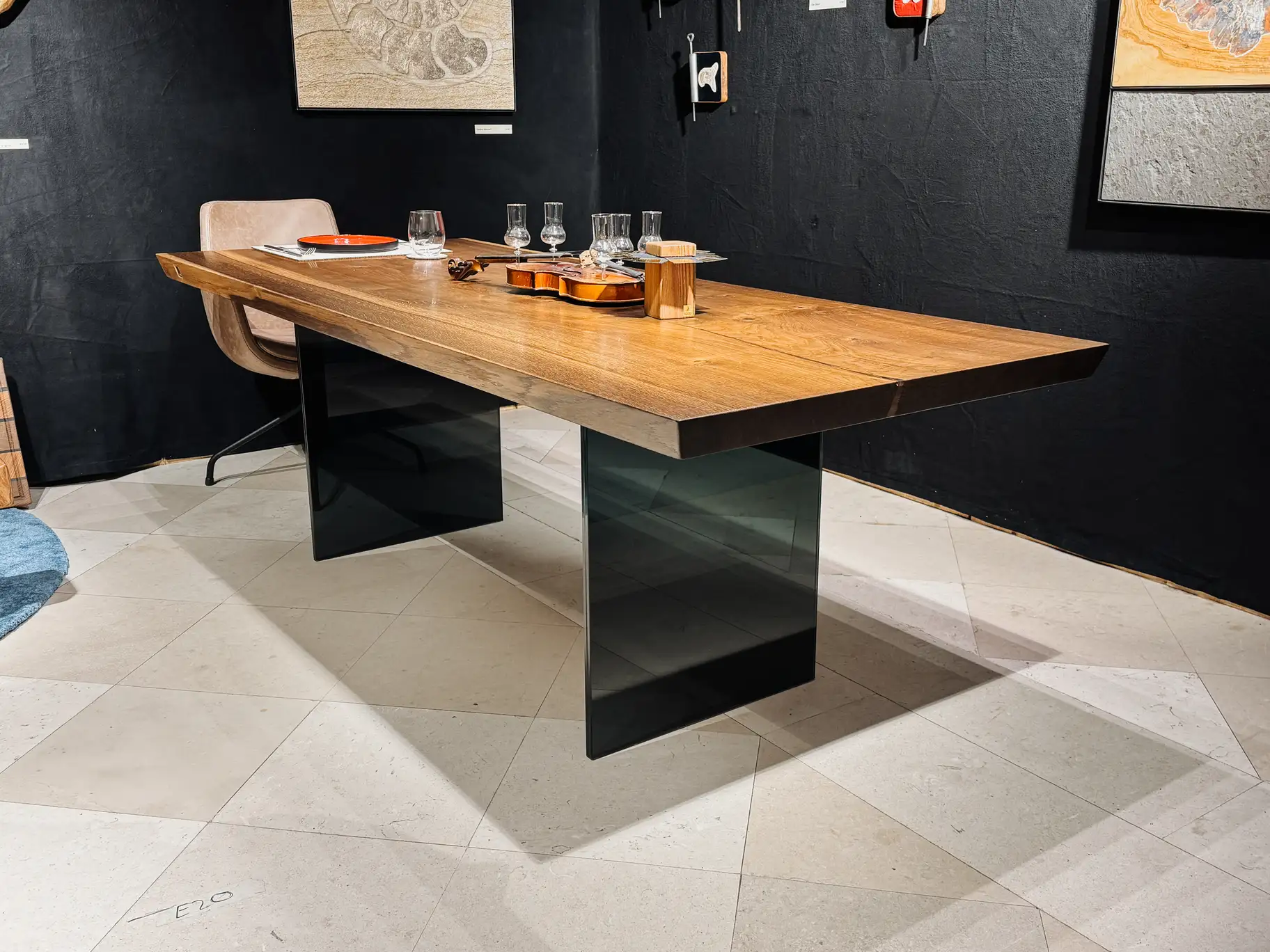 Escritorio de roble macizo con acabado oscuro, borde recto y patas de vidrio elegantes.