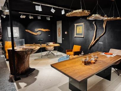 Moderner Baumstammtisch aus massiver dunkler Eiche mit klarer Linienführung und dunklen Glasbeinen