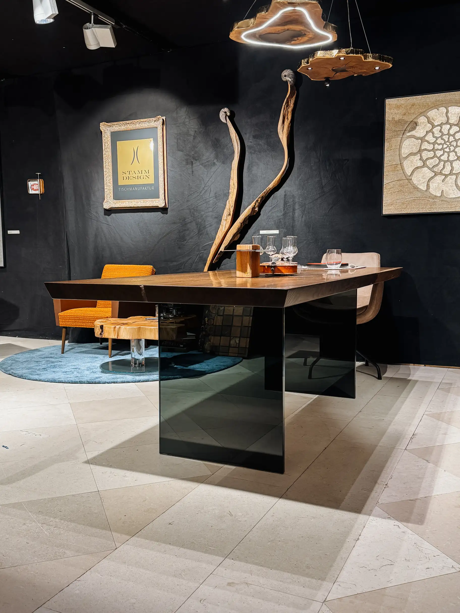 Escritorio de diseño en madera de roble oscuro con vetas marcadas y elegantes patas de vidrio de Stammdesign