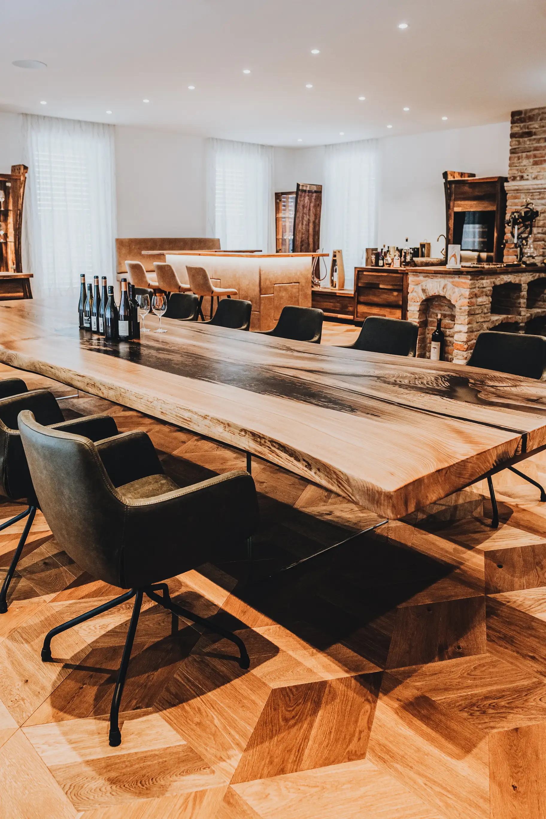 Table à manger en bois massif d’orme de Stammdesign avec pieds en verre dans une cave à vin