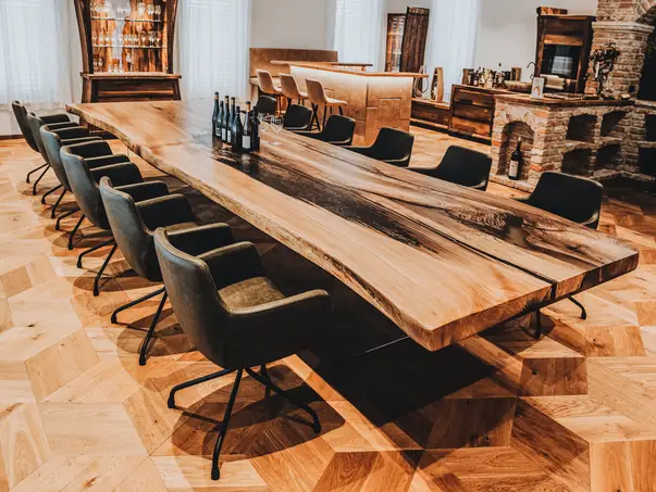Mesa de madera maciza de olmo con patas de vidrio resistentes para 12 personas en una bodega elegante