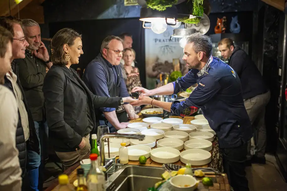 Koch Tommy Eder erklärt den Teilnehmern beim Stammdesign Gourmet-Event die Zubereitung