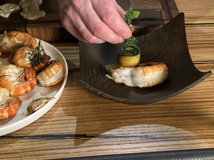 Garnelen elegant angerichtet auf Holzteller bei einem Gourmet-Event von Stammdesign