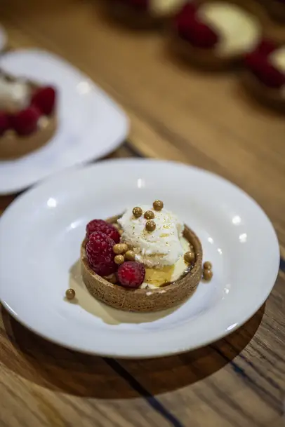 White plate with high-quality dessert on a wooden table, elegantly arranged