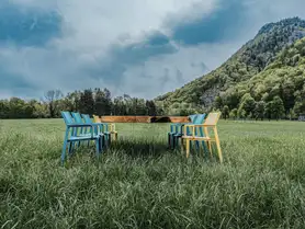 Tisch von Stammdesign aus einem Baumstamm mit Glasbeinen, der optisch schwebt, auf einer Wiese