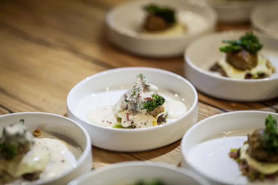 Comida gourmet exquisitamente presentada en la manufactura de mesas Stammdesign