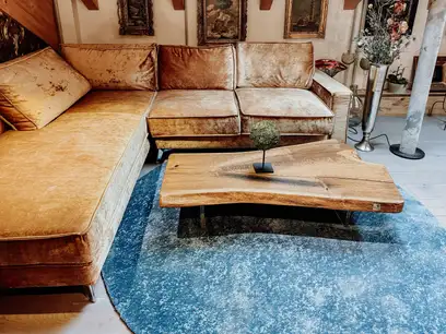 Mesa de café de diseño de Stammdesign hecha de un tronco de árbol con vetas elegantes y tonos cálidos de madera de roble.