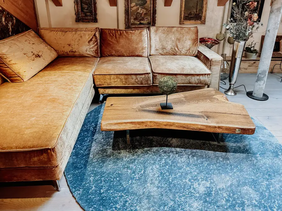 Mesa de café de diseño de Stammdesign hecha de un tronco de árbol con vetas elegantes y tonos cálidos de madera de roble.