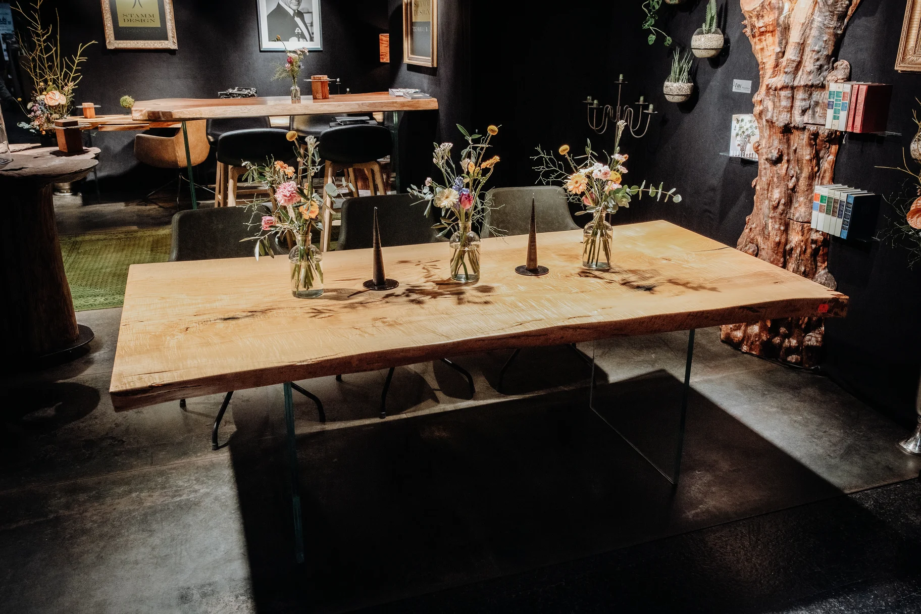 Handcrafted dining table from a tree stump by Stammdesign with a natural ash wood edge.