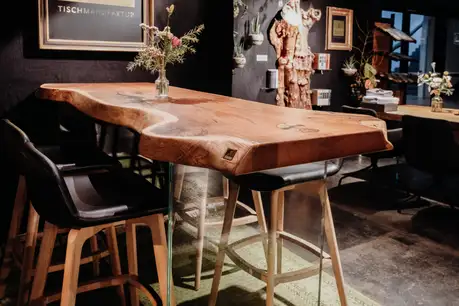 Heavy-duty standing table for hospitality with sturdy glass legs and durable surface by Stammdesign.