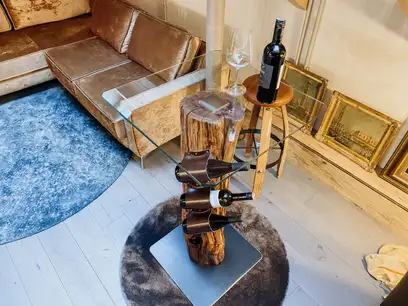 Handcrafted wine bar by Stammdesign with wine bottle holder made from a plum tree trunk.