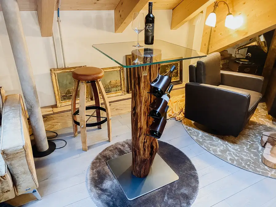 Handcrafted wine bar by Stammdesign with wine bottle holder made from a plum tree trunk.