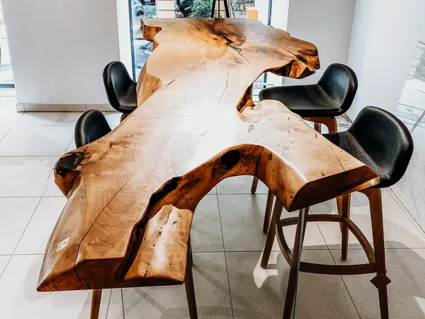 Mesa alta exclusiva hecha de un tronco de árbol con patas de vidrio robustas de Stammdesign, fabricada en madera de peral.