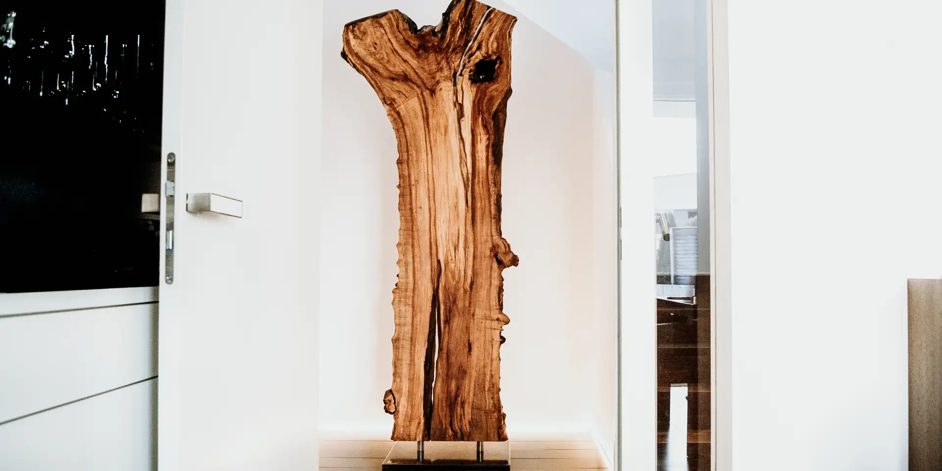 Scultura in legno di Stammdesign da un tronco d'albero, in piedi con supporto metallico per interni moderni.