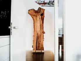 Escultura de madera de Stammdesign hecha de un tronco de árbol, de pie con soporte metálico para interiores modernos.