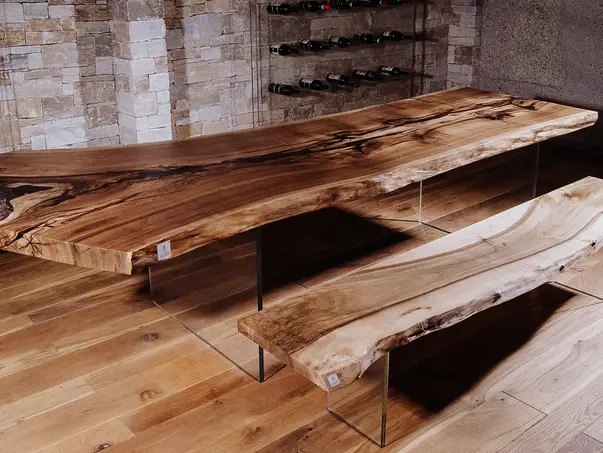 Banco hecho de un tronco de árbol con patas de vidrio resistentes de Stammdesign.