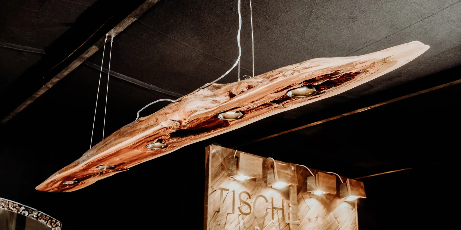 Modern designer lamp from a tree trunk, as a hanging light, crafted from wood by Stammdesign.