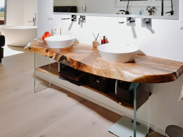 Lavabo hecho de un tronco de árbol con estructura de madera natural de Stammdesign en el baño.