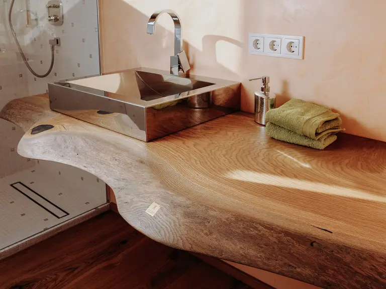 Lavabo designer di Stammdesign realizzato con un tronco d'albero e venatura elegante per il bagno.