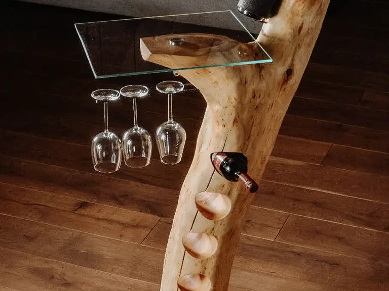 Bar da stand di alta qualità realizzato con un tronco d'albero, con supporto per bottiglie e calici da vino e piano in vetro stabile.