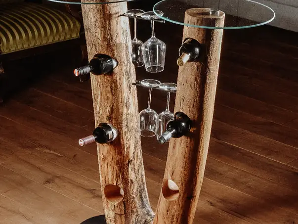 Barra de pie con soportes para vino de un tronco de árbol y dos superficies de vidrio de Stammdesign.