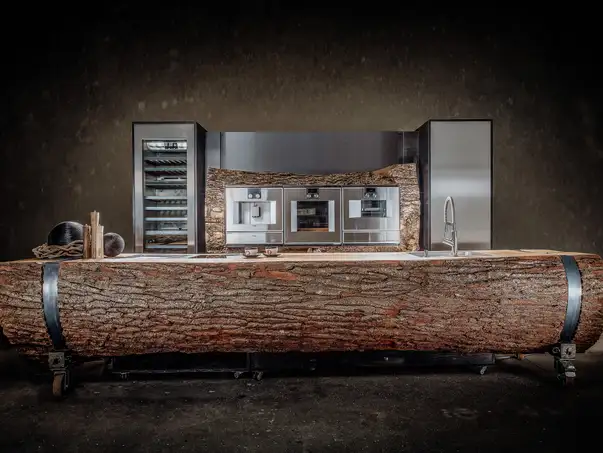 Isola da cucina realizzata con un tronco d'albero e superficie in legno massello resistente per gastronomia e eventi, vista frontale.