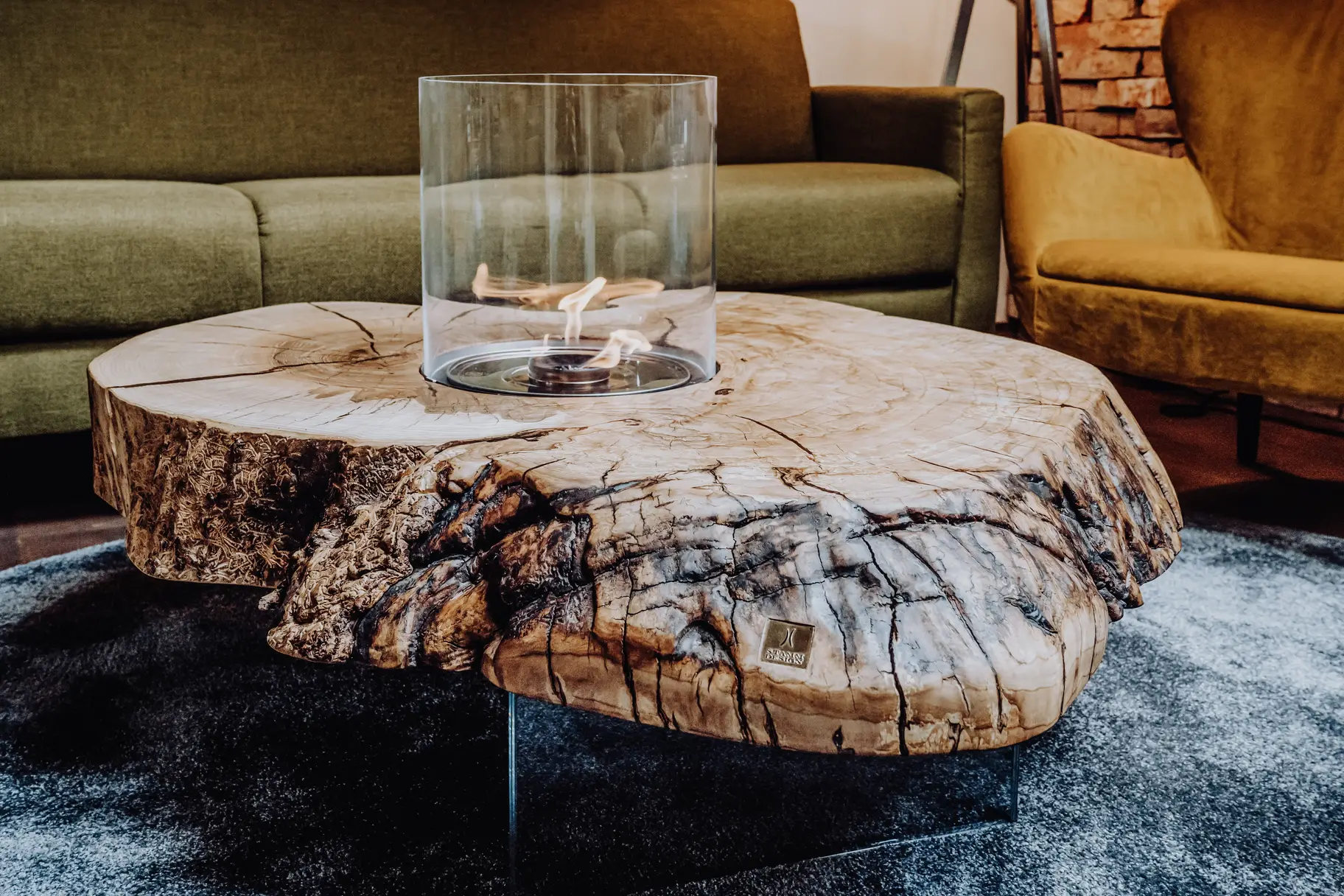 Designer Feuertisch aus einem Baumstamm mit eleganter Maserung und massiver Tischplatte aus Esche