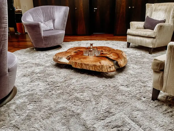 Mesa de café de diseño hecha de un tronco de árbol con vetas exclusivas y una elegante superficie de olmo.