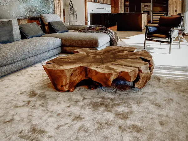 Mesa de café rústica hecha de un tronco de árbol con borde natural y resistente tablero de nogal.