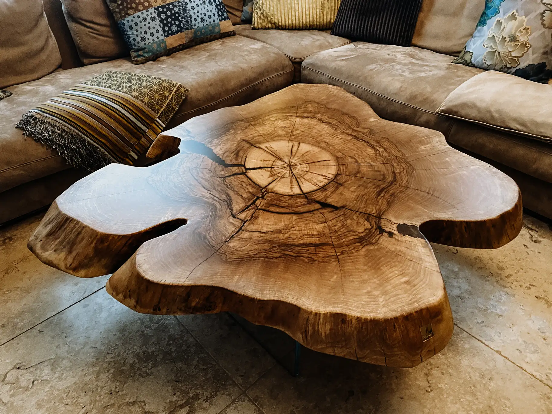 Unique coffee table made from a tree trunk with striking grain and elegant walnut tabletop.