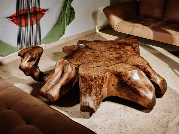 Mesa maciza de raíz hecha de un tronco con veta natural y tablero de nogal resistente.
