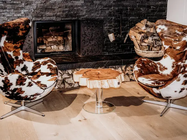 Mesa de café de diseñador hecha de una sección de árbol con borde elegante y base de vidrio, fabricada en tejo.