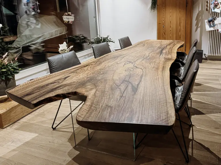 Tavolo in legno massello realizzato con un tronco, con una struttura del legno distintiva e gambe in vetro di noce
