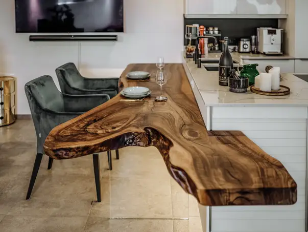 Mesa de cocina artesanal de un tronco con veta exclusiva y tablero de roble, vista lateral.