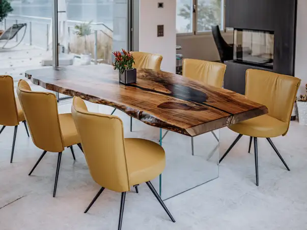 Tavolo di design naturale da un tronco con venatura del legno espressiva, realizzato in noce.