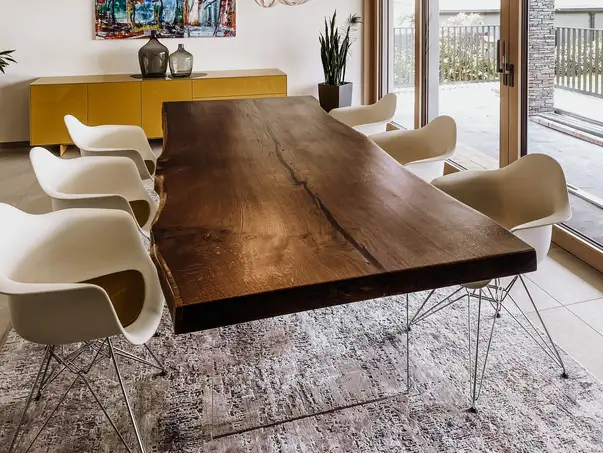 Tavolo da pranzo di design da un tronco con bordo naturale e gambe in vetro eleganti in quercia.