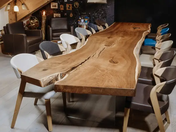 Mesa masiva de diseño de un tronco con patas elegantes de vidrio y mesa resistente de roble, vista frontal.
