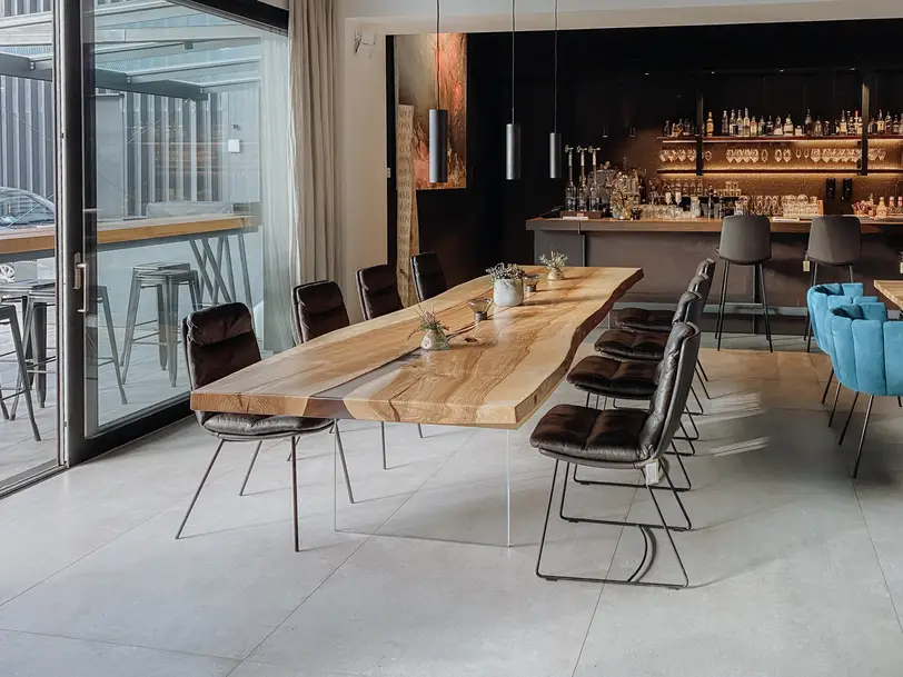 Moderner Designer Gastrotisch aus einem Baumstamm mit stabiler Tischplatte und Glasbeinen aus Esche