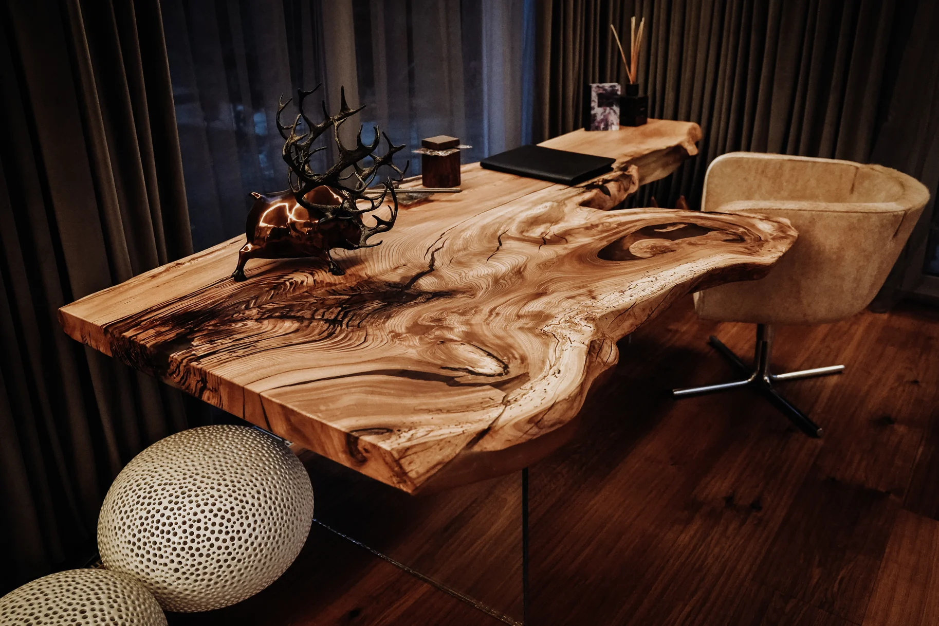 Escritorio rústico hecho de tronco de árbol con patas de vidrio y veta única de olmo