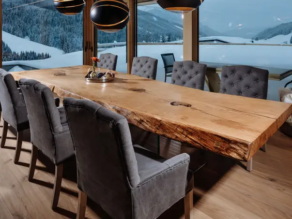 Mesa de comedor natural hecha de tronco con estructura de madera distintiva y patas de vidrio, vista lateral