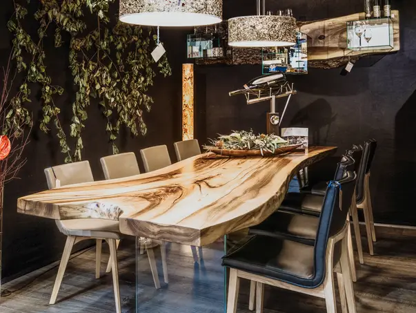 Mesa artesanal de tronco con superficie robusta, borde natural y patas de vidrio de Stammdesign