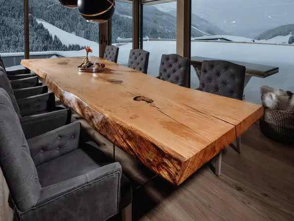 Mesa de salón moderna de diseño hecha de tronco con superficie robusta y patas de vidrio, vista 1