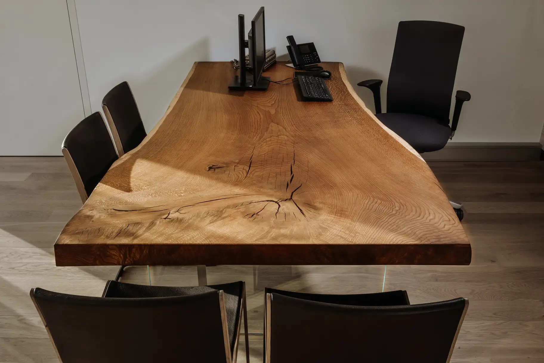 Unique office desk made from a tree trunk with natural live edge and solid wood tabletop, front view
