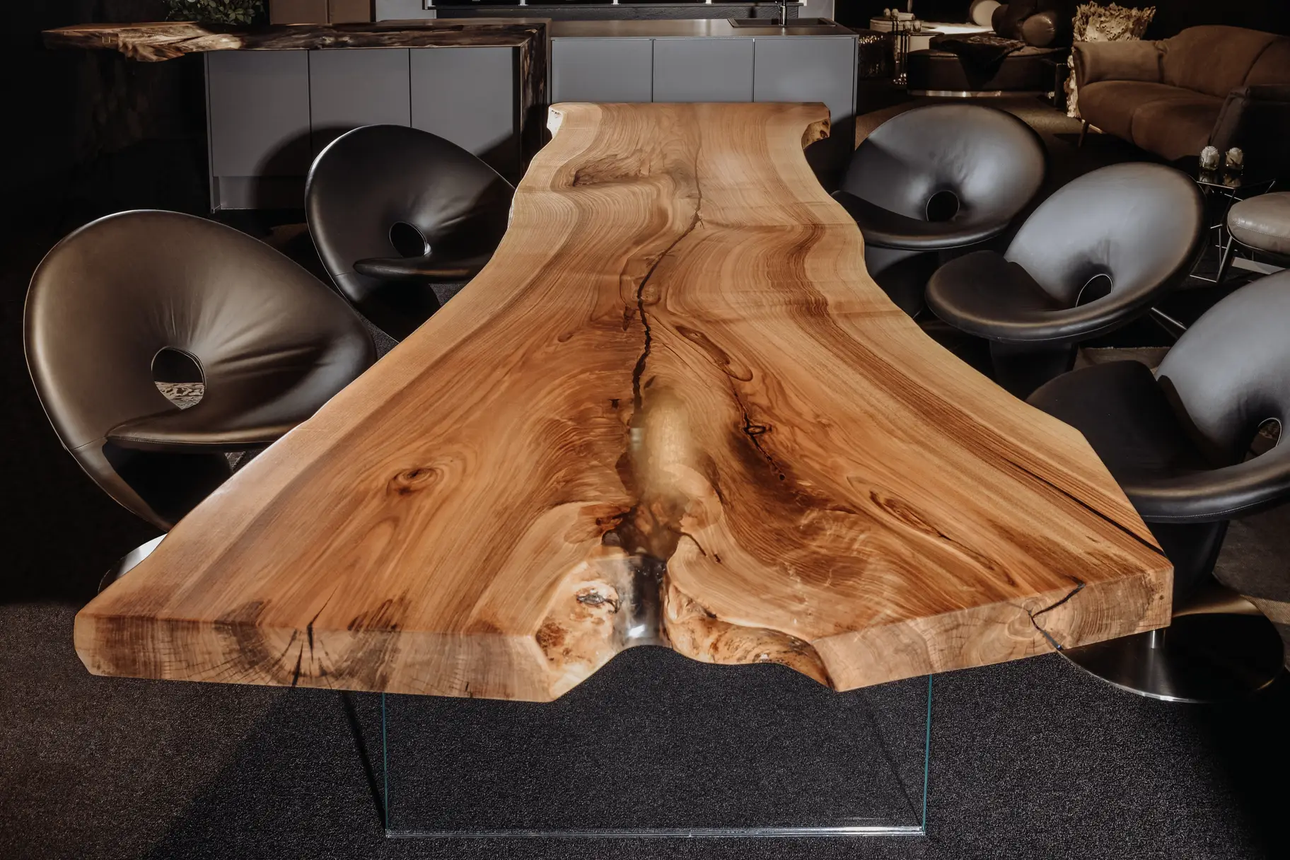 Naturbelassener Wohnzimmertisch aus einem Baumstamm mit markanter Holzstruktur und Glasbeinen, Frontansicht