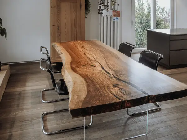 Mesa de comedor maciza de madera con patas de vidrio, hecha de un tronco de árbol