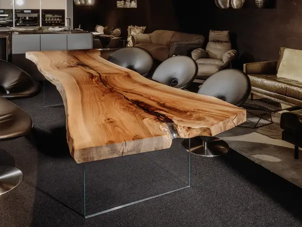 Mesa de salón natural de tronco con grano de madera distintivo y patas de vidrio