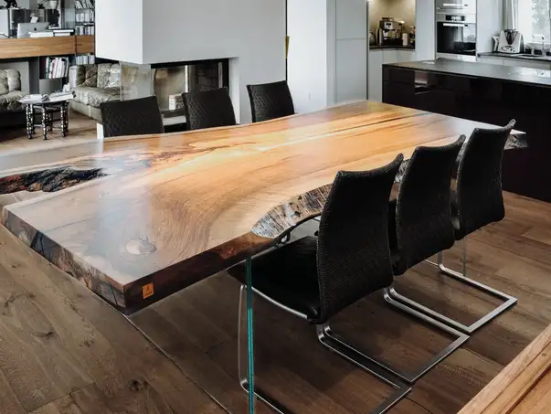 Ampio tavolo da pranzo di Stammdesign in tronco d’albero con venatura unica e piano robusto, vista laterale