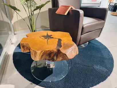 Solid side table made from a robinia tree slice with striking grain and glass legs